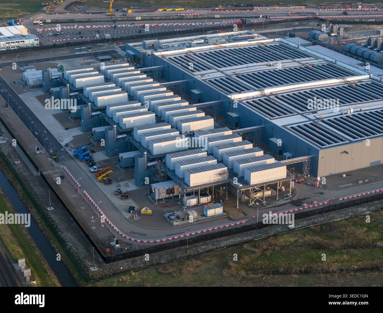Vista aerea di un grande complesso industriale con file di unità di raffreddamento ed edifici con tetto piatto sotto luce soffusa a Groninga, Groninga, Olanda Foto Stock