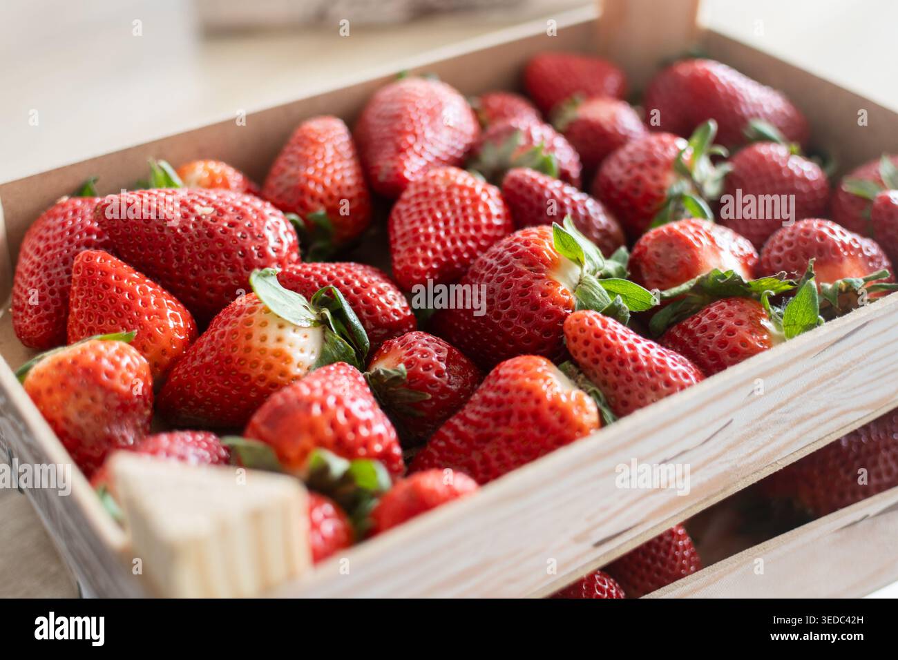 Fragole fresche su scatole di legno su tavola di legno Foto Stock