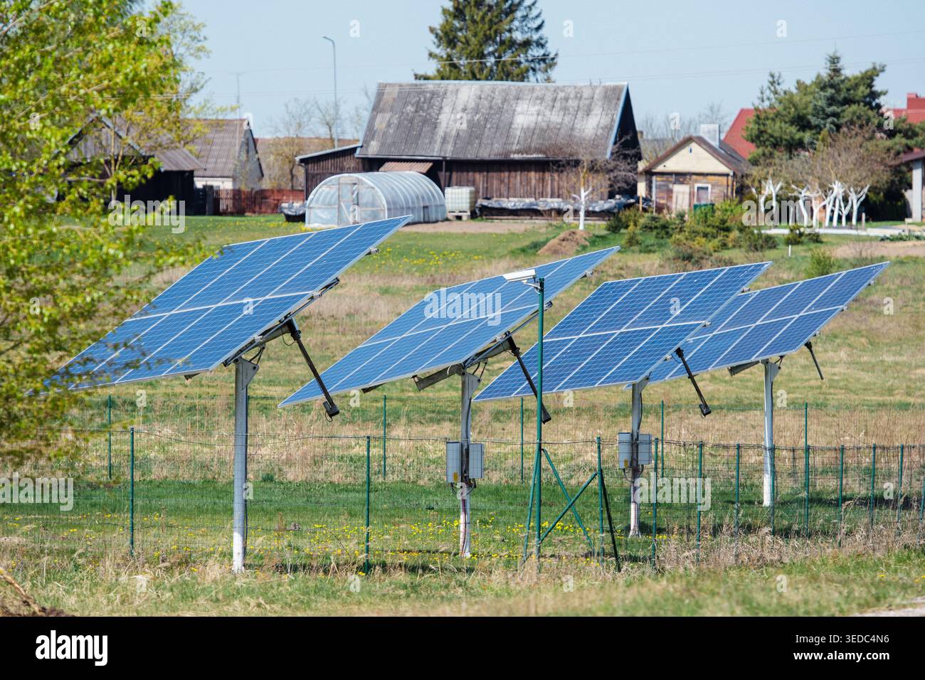 Vista ravvicinata di una fila di pannelli solari installati in una piccola città di campagna in una giornata di sole Foto Stock