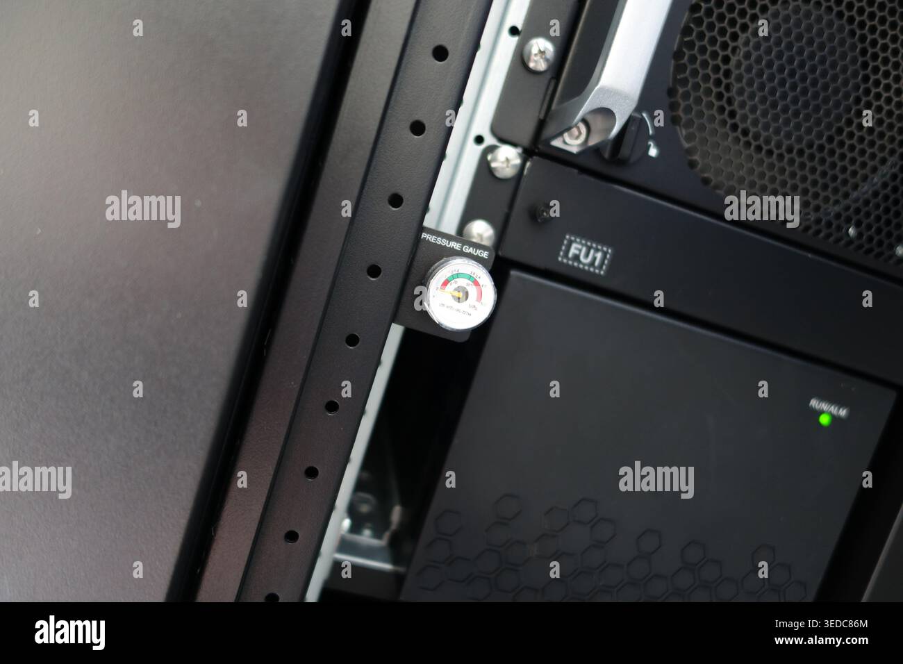 Vista ravvicinata di un manometro montato in un server rack, che mostra la tecnologia e l'infrastruttura utilizzate per il monitoraggio delle prestazioni delle apparecchiature e del saf Foto Stock