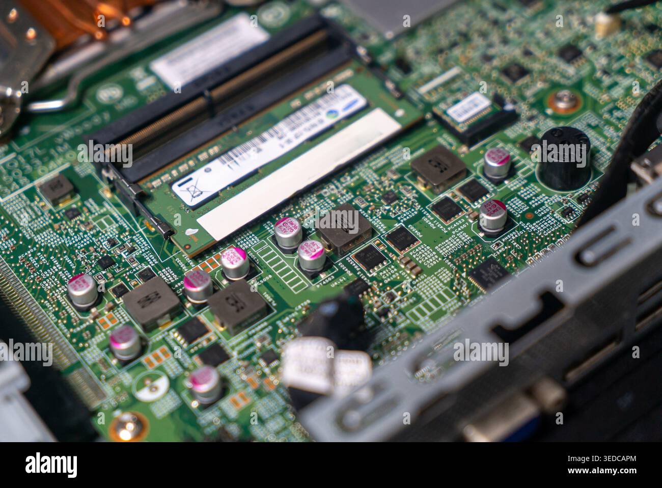 Vista ravvicinata di una scheda a circuito stampato dettagliata con un modulo RAM e vari componenti elettronici, che mostra la tecnologia e gli elementi di design complessi Foto Stock