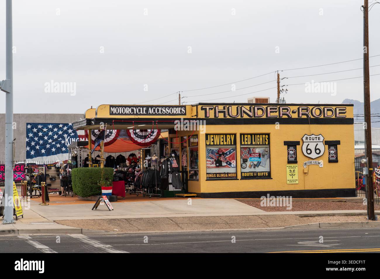L'esterno del negozio Thunder-Rode Motorcycle Accessories con cartelli della Route 66 e esposizioni di merce in una giornata nuvolosa a Kingman, Arizona. Foto Stock