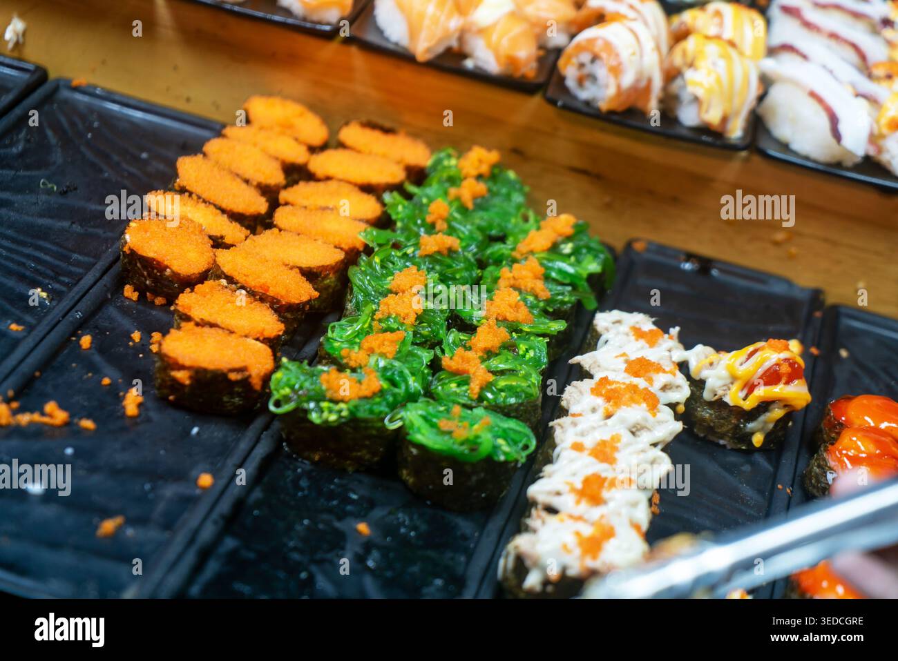 Un vivace assortimento di sushi caratterizzato da texture e ingredienti colorati, perfetto per catturare l'essenza della cucina giapponese e dell'arte culinaria. Foto Stock