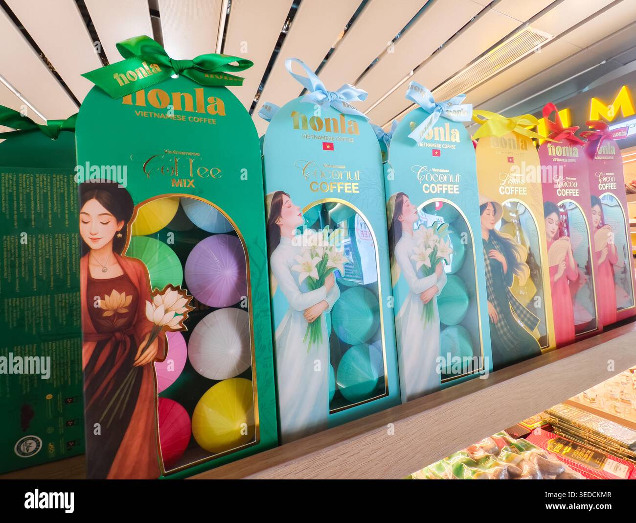 Scatole regalo vietnamite per caffè liofilizzato a marchio NONLA, con confezioni illustrate in vari colori su uno scaffale, Vietnam Foto Stock