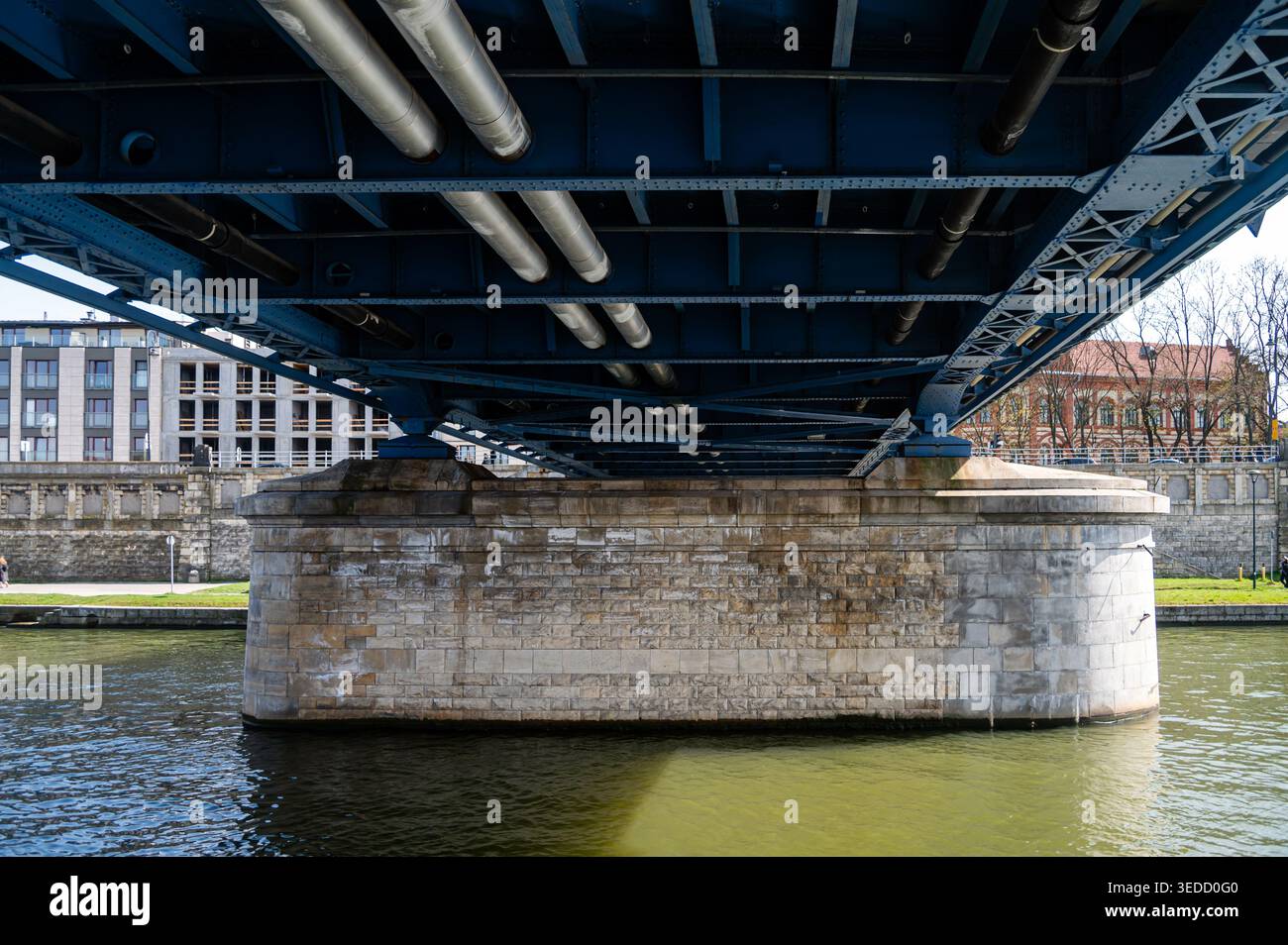 I sostegni del ponte e la superficie del fiume sono visibili con edifici e spazi verdi nelle vicinanze. Foto Stock