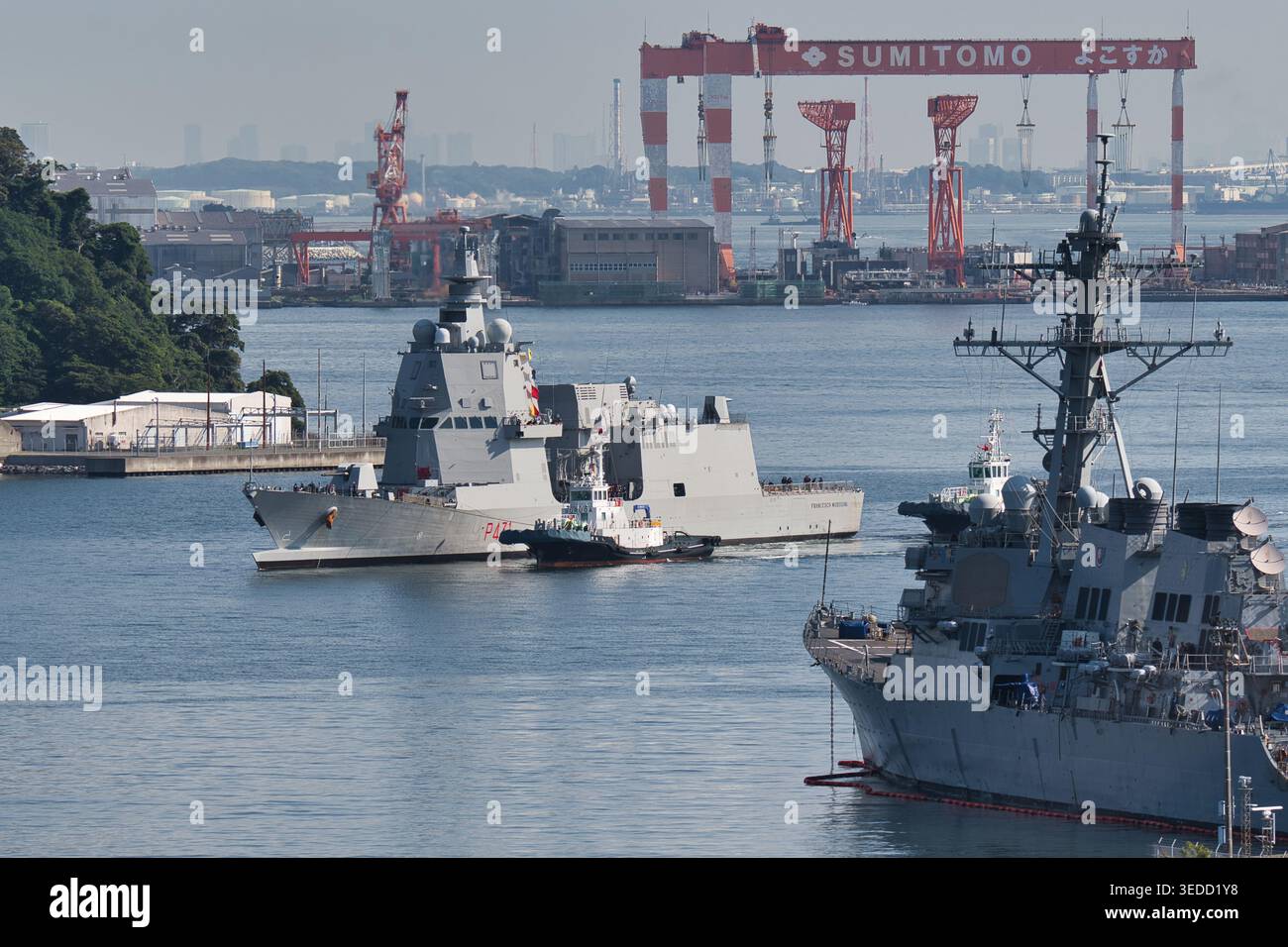 Marina militare Italiana Francesco Morosini (P431) OPV classe PPA che entra a Yokosuka con la gru Sumitomo, l'assistenza rimorchiatore e lo sfondo Arleigh Burke Foto Stock