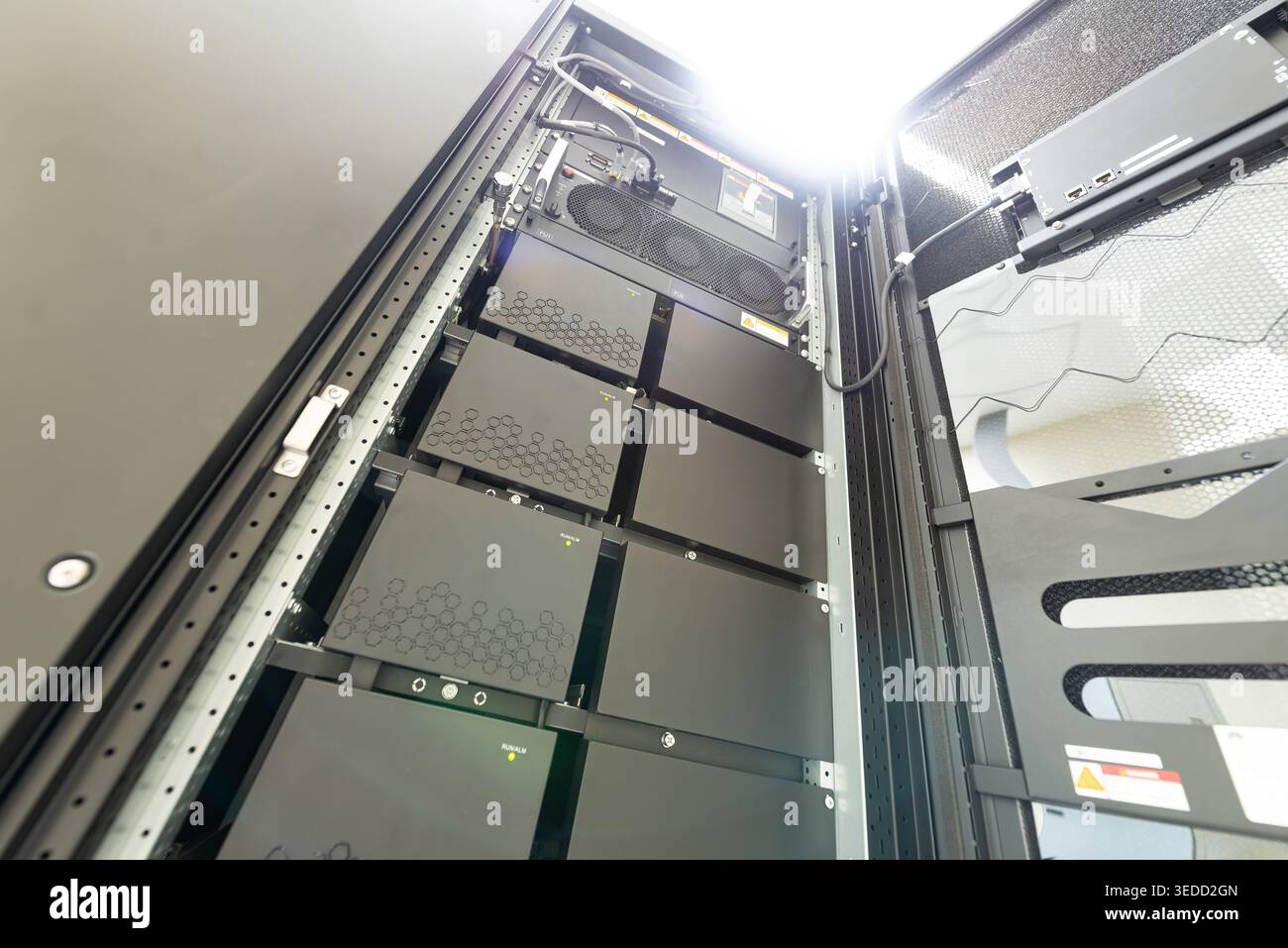 Vista ravvicinata di un moderno rack server per data center che presenta apparecchiature avanzate, unità di raffreddamento e soluzioni di storage organizzate per un'elaborazione efficiente Foto Stock