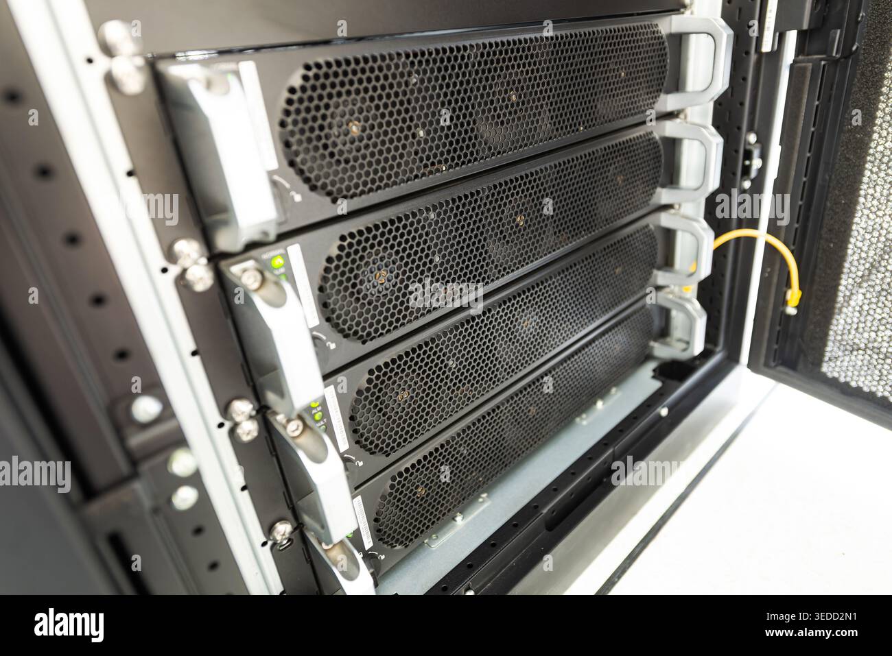 Questa immagine mostra le unità rack server ad alte prestazioni in un moderno data center, evidenziando il design complesso, i sistemi di raffreddamento e la cabina organizzata Foto Stock