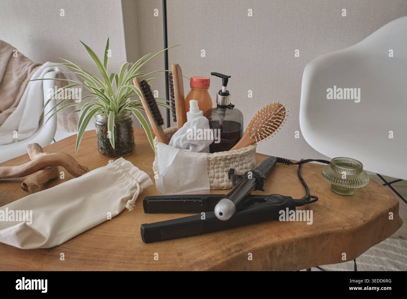 Prodotti per la cura dei capelli e strumenti per lo styling disposti su un tavolo di legno per la cura di sé Foto Stock