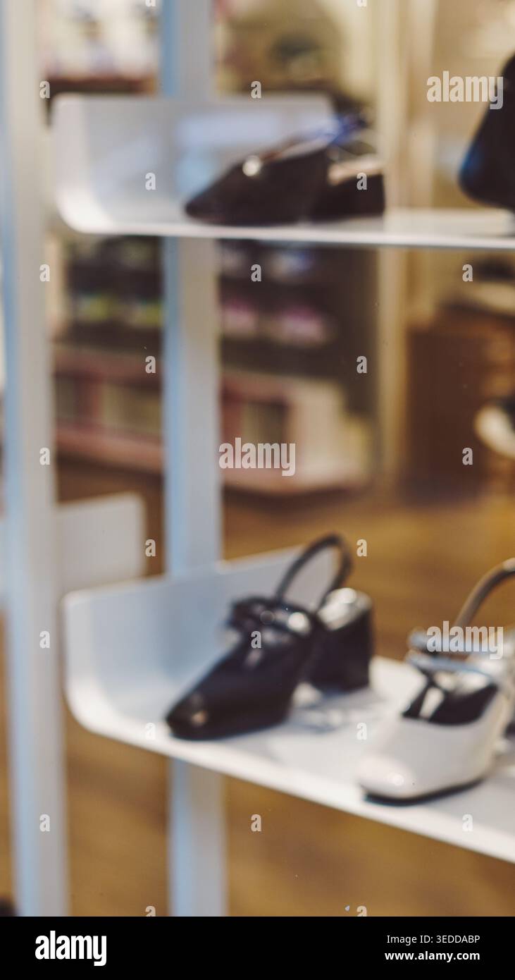 Sfondo sfocato verticale delle scarpe da donna su scaffali bianchi in un negozio di moda Foto Stock