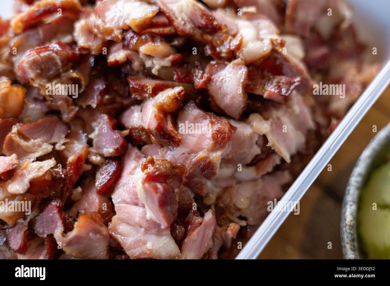 Una vista ravvicinata che mostra un mucchio di carne di maiale tagliata appena cucinata. Deliziosa pancetta arrostita con ricchi grassi e alto contenuto proteico pre Foto Stock