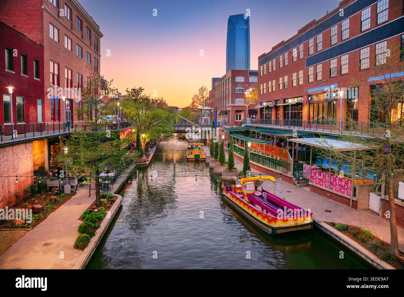 Oklahoma City, Oklahoma, Stati Uniti. Immagine del paesaggio urbano del centro di Oklahoma City con il canale di Bricktown e il bellissimo tramonto primaverile. Foto Stock