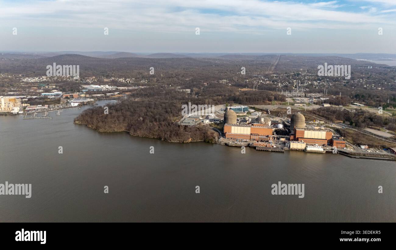 Vista aerea della centrale nucleare Indian Point Energy Center sulla riva del fiume Hudson, circondata da fitte foreste e colline ondulate in B Foto Stock