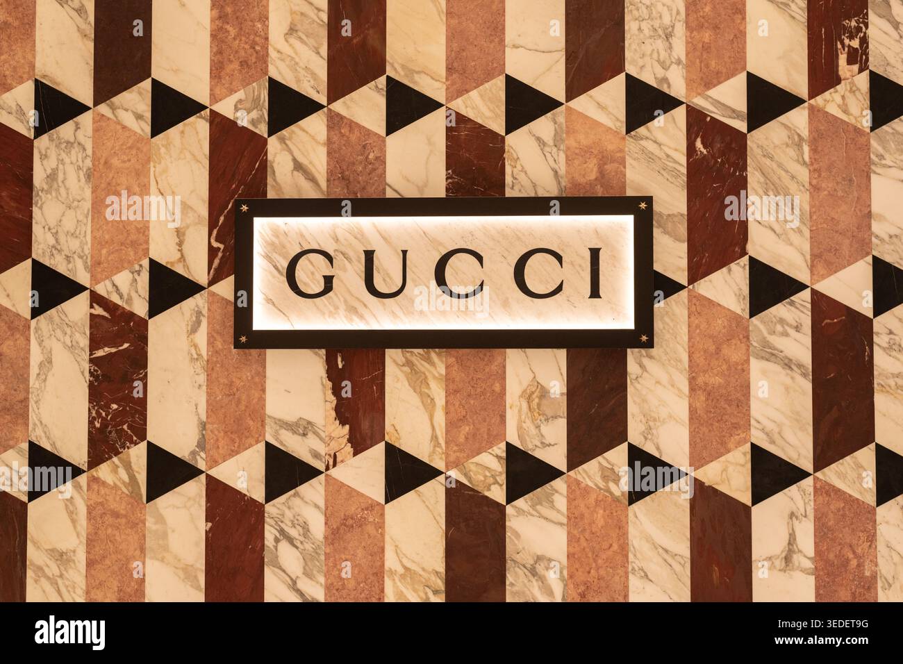 Iscrizione Gucci sull'esterno colorato di un negozio decorato con un motivo geometrico di poligoni il 13 gennaio 2024, a Bangkok, Thailandia Foto Stock