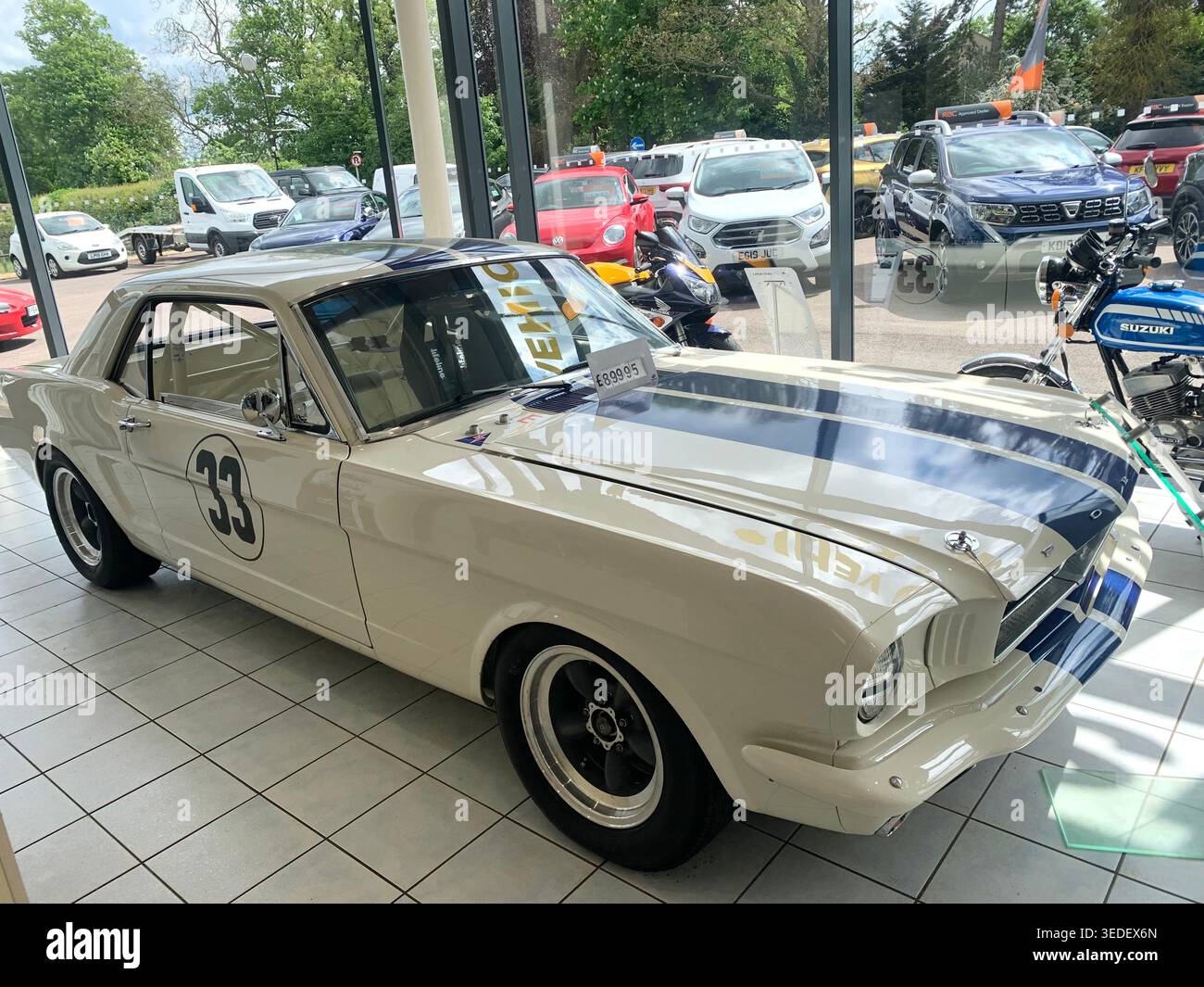 Auto da corsa ford Mustang classica esposta in uno showroom in vendita nel Northamptonshire Inghilterra presso il garage di Earls Barton modello bianco d'epoca 1960 sport - Immagine stock catturata con smartphone