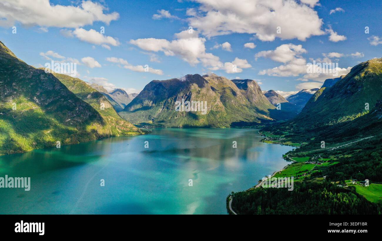 Questa foto panoramica con drone aereo cattura il suggestivo fiordo di Stryn con montagne verdi che si innalzano su entrambi i lati e acque blu calme sotto, fotografate Foto Stock
