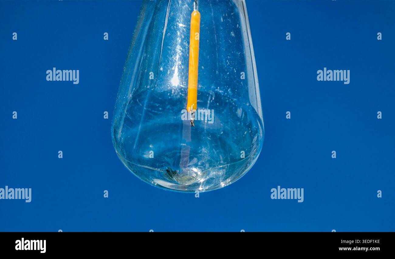 Una lampadina per esterni contro un cielo azzurro Foto Stock