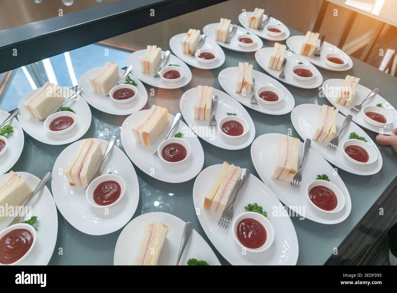 Un'elegante esposizione di panini freschi serviti su piatti bianchi insieme a piccoli piatti di salsa. Perfetto per eventi di catering, pranzi o riunioni. Foto Stock