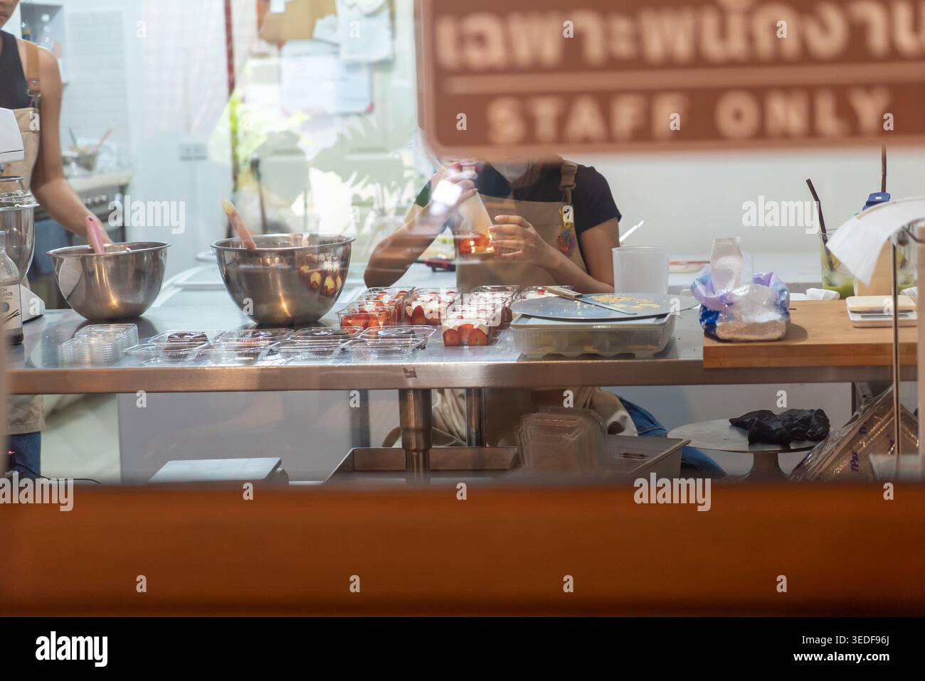 Una vivace scena culinaria che mostra la preparazione del cibo in corso, che mette in evidenza gli chef al lavoro, gli ingredienti freschi e uno spazio di lavoro organizzato. Perfetto per c Foto Stock