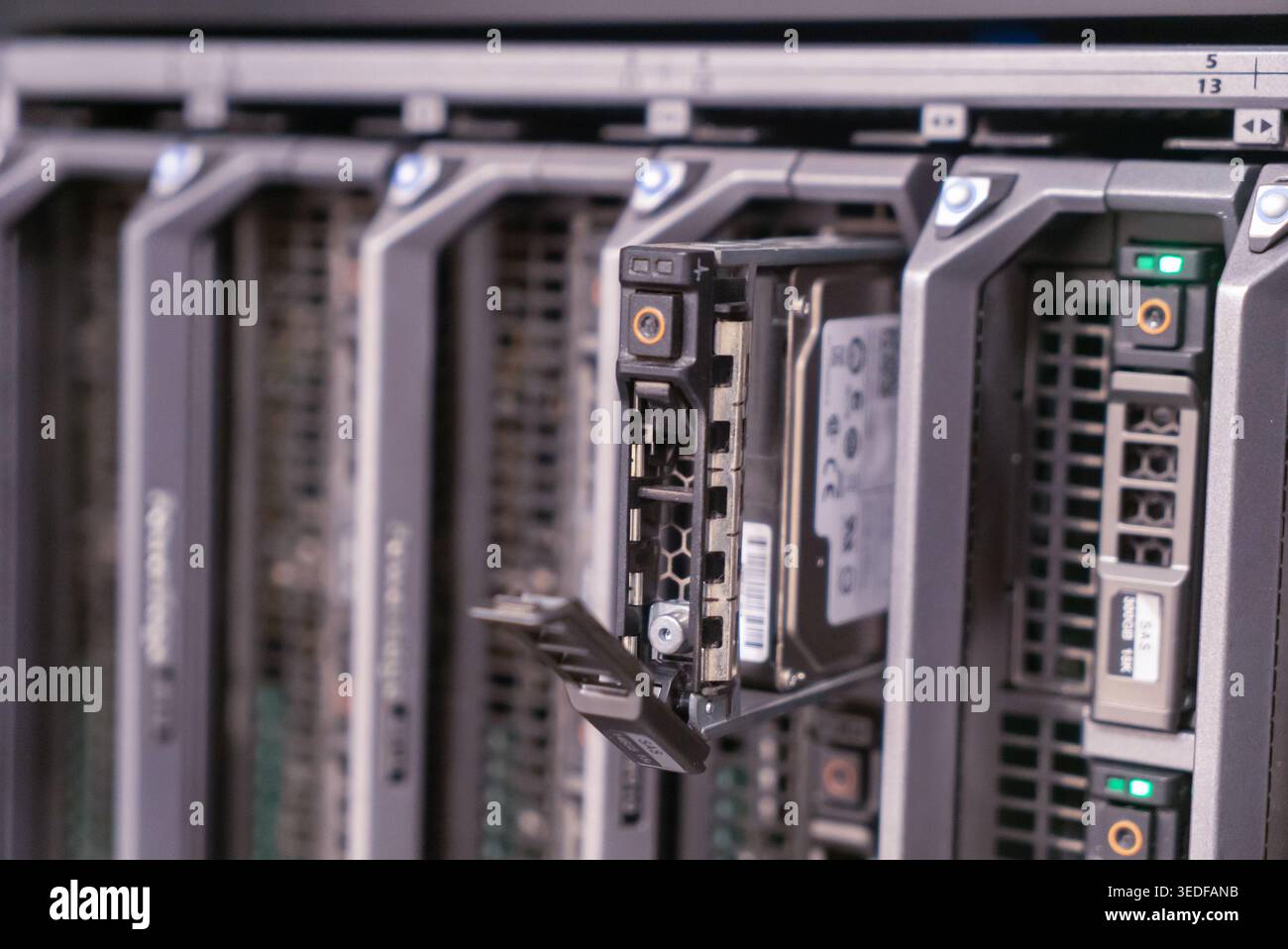 Vista dettagliata di un server rack che mostra un disco rigido inserito, evidenziando la tecnologia e le soluzioni di storage dei dati in un ambiente informatico moderno Foto Stock