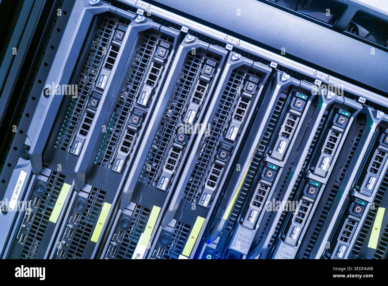 Vista ravvicinata di un moderno rack server per data center che mostra più server blade, evidenziando tecnologia e hardware avanzato in un ambiente strutturato Foto Stock