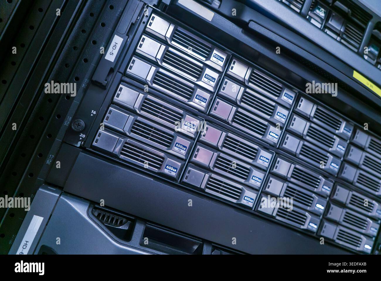 Vista ravvicinata di un server rack con più unità di storage, che mostra la tecnologia e l'infrastruttura moderne essenziali per la gestione dei dati e. Foto Stock