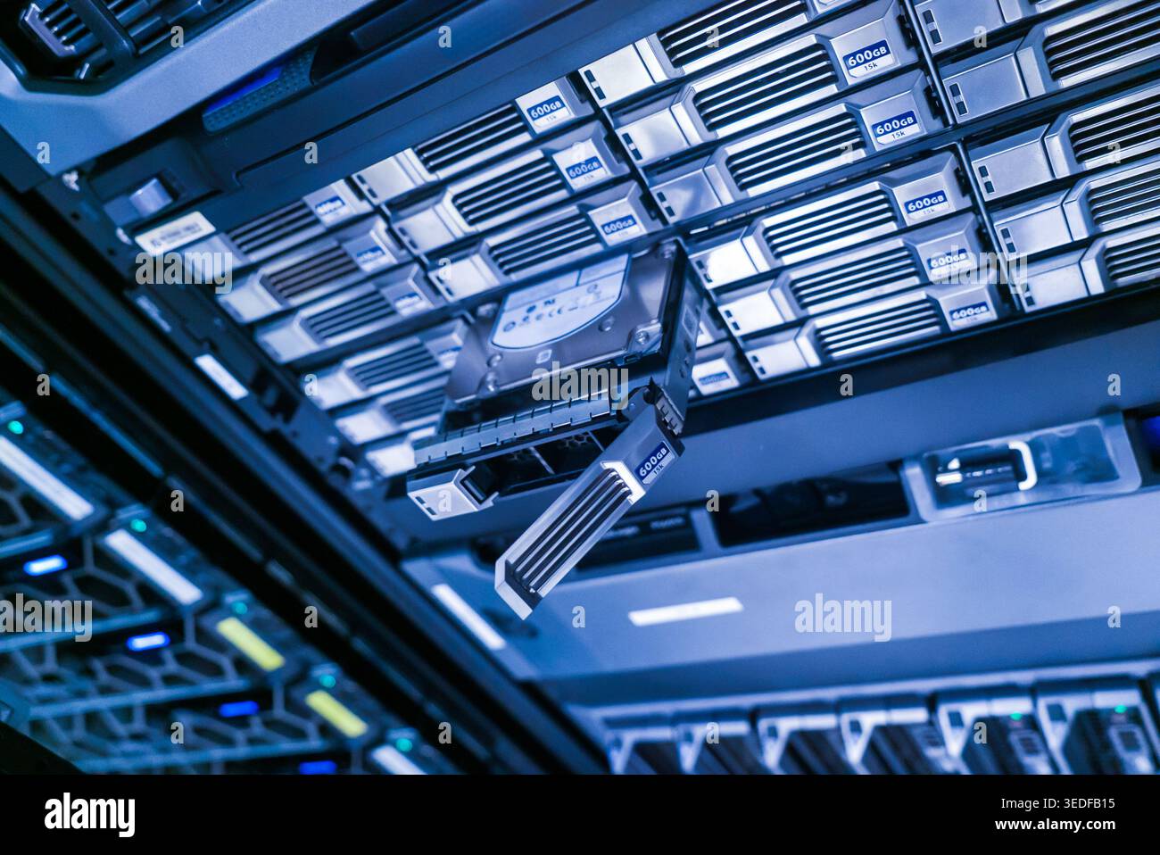Vista ravvicinata di un disco rigido pronto per la connessione all'interno di una moderna sala server. Questa immagine cattura l'essenza delle violazioni della tecnologia e della gestione dei dati Foto Stock