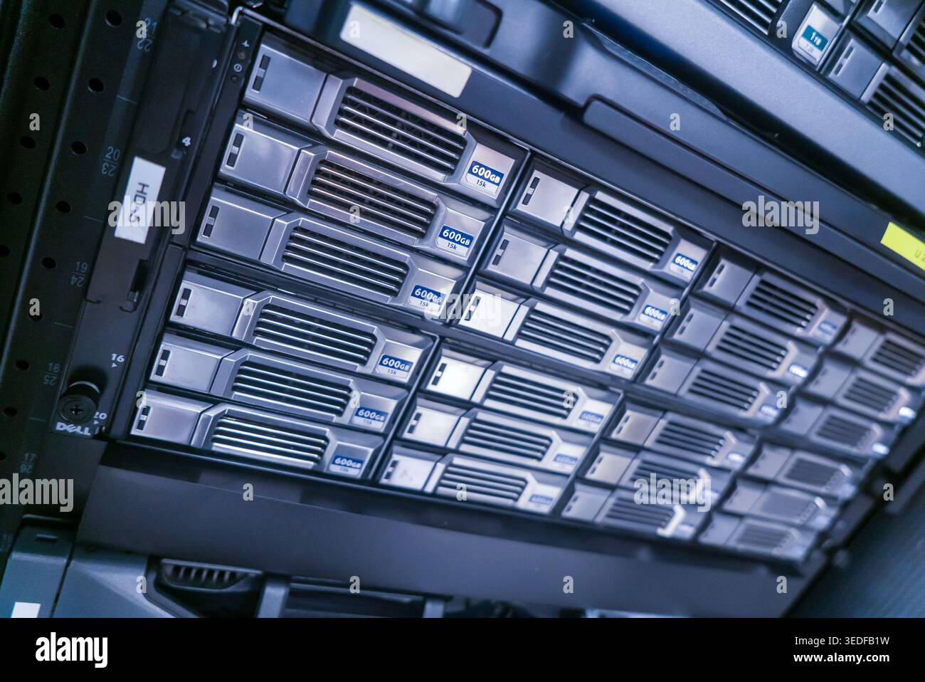 Vista ravvicinata di un moderno rack di archiviazione dati che presenta più unità server attrezzate per un'efficiente organizzazione e elaborazione dei dati. Ideale per techno Foto Stock