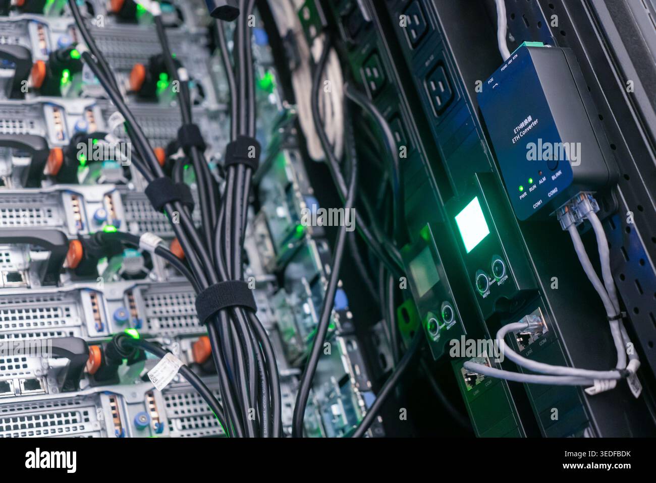 Vista ravvicinata del server rack che mette in evidenza le apparecchiature di rete, i cavi e i dispositivi di monitoraggio in un data center, che illustra la tecnologia e l'organizzazione i. Foto Stock