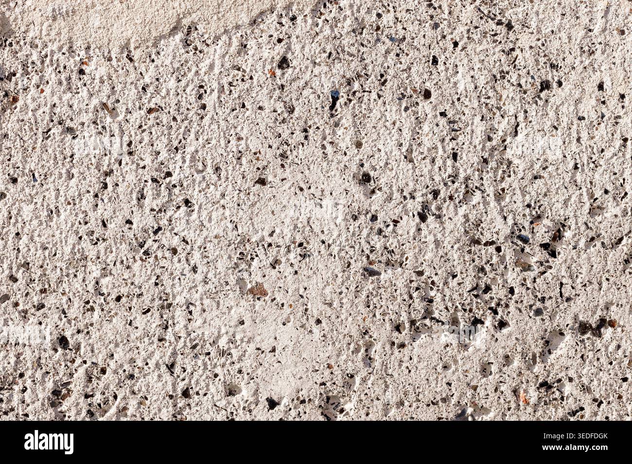 Struttura in calcestruzzo poroso con inclusioni minerali nere, sfondo in pietra grigia Foto Stock