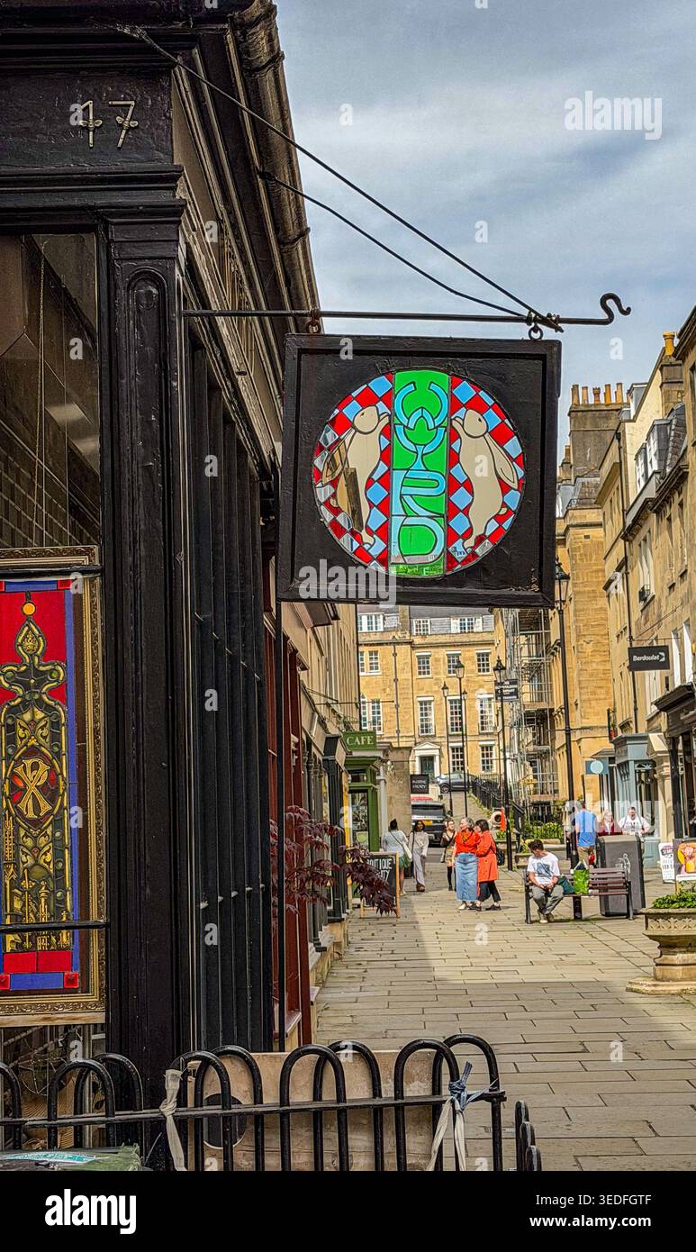 Una vista di una pittoresca strada europea con un cartello di vetrata appeso per lo studio di vetrate colorate Wyrd Bath UK - Immagine stock catturata con smartphone