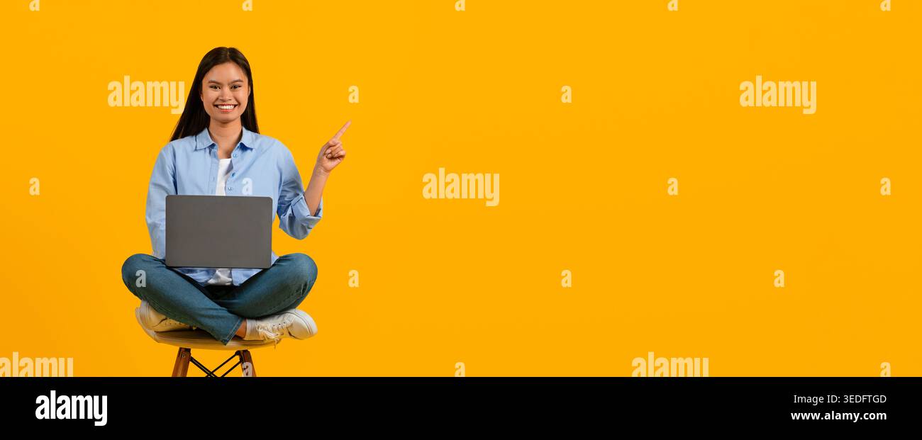 Una giovane donna siede sullo sgabello con un notebook e punti nello spazio luminoso Foto Stock