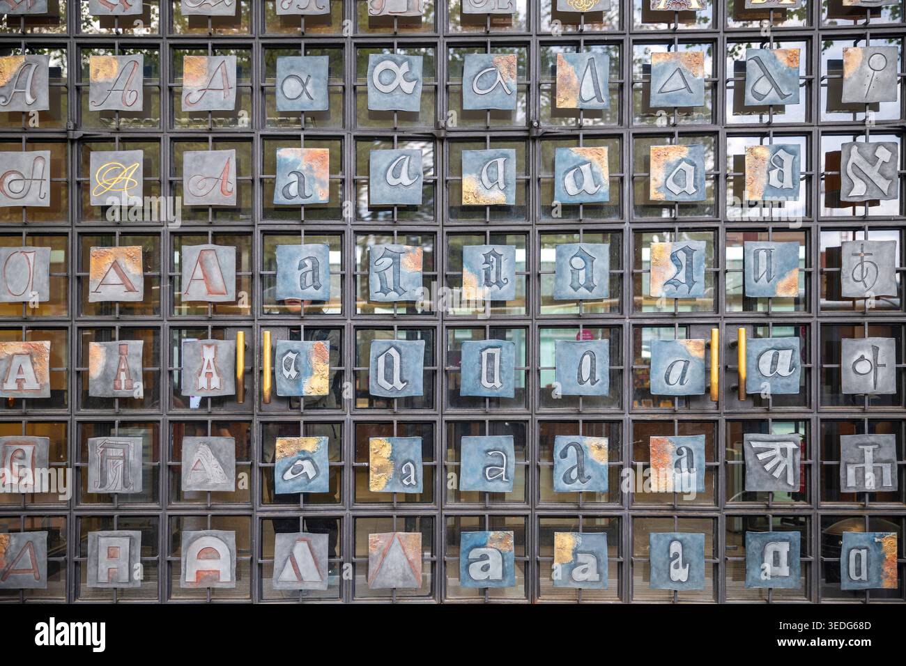 Vista ravvicinata della porta a griglia metallica presso il Zentral und Landesbibliothek Berlin con piastrelle singole che mostrano varie versioni tipografiche della lettera Foto Stock