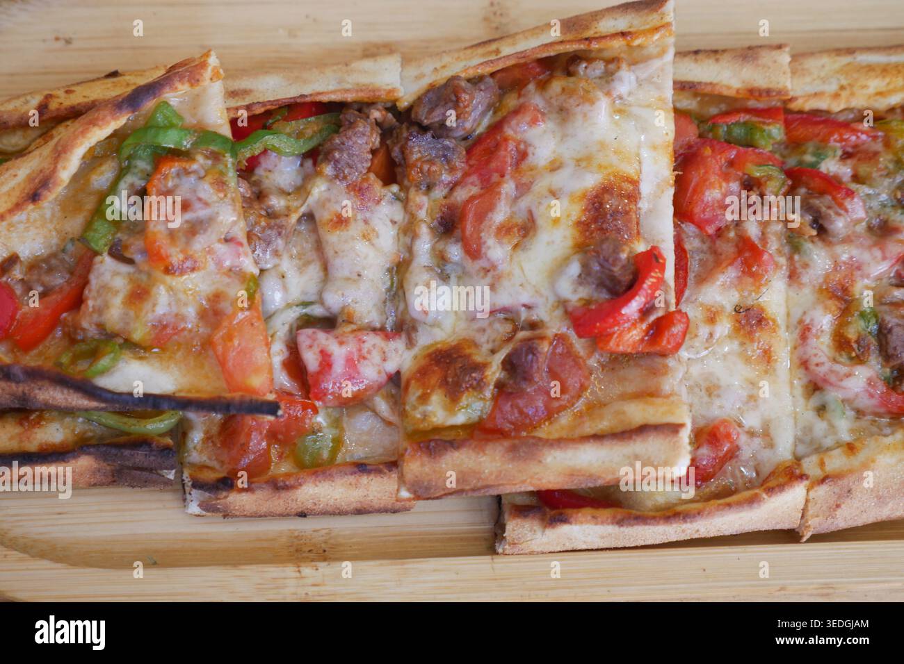 pide turco con condimenti serviti su un piatto di legno Foto Stock