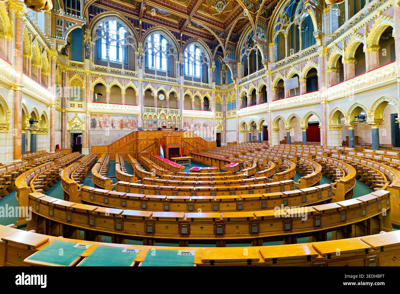 L'interno dell'edificio del Parlamento di Budapest mostra file di posti a sedere in legno e grandi finestre. La camera è vuota e tranquilla. Foto Stock