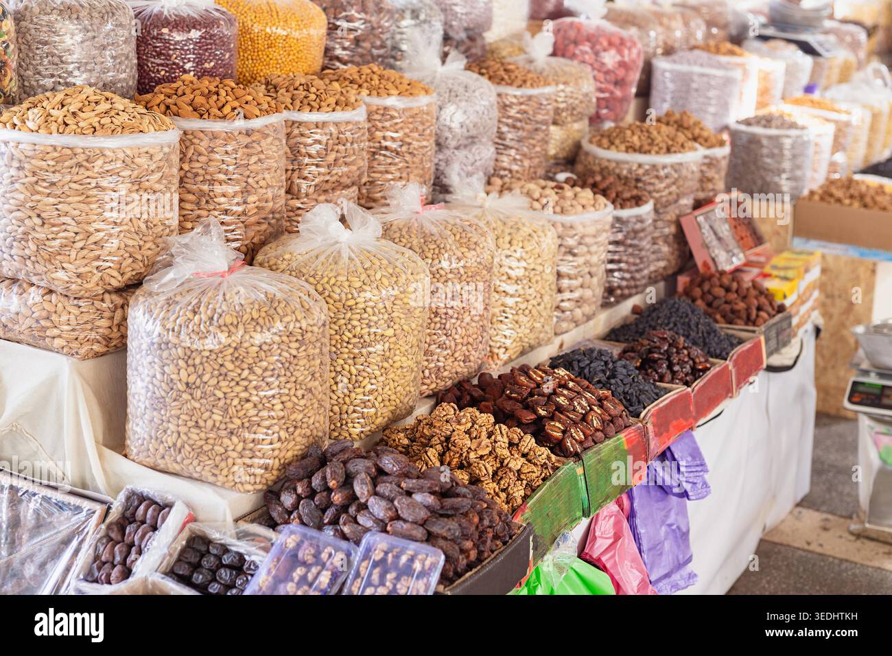 Frutta secca e frutta secca esposte in grandi sacchetti al bazar Siab di Samarcanda. Abbondante bancarelle di mercato con mandorle, pistacchi, datteri, noci e uva passa in vendita. Foto Stock