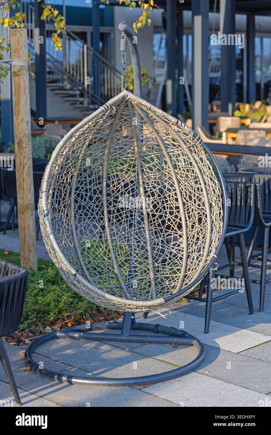 Sedia a sdraio per il nido d'uovo appeso al patio all'aperto, il giorno di sole autunnali Foto Stock