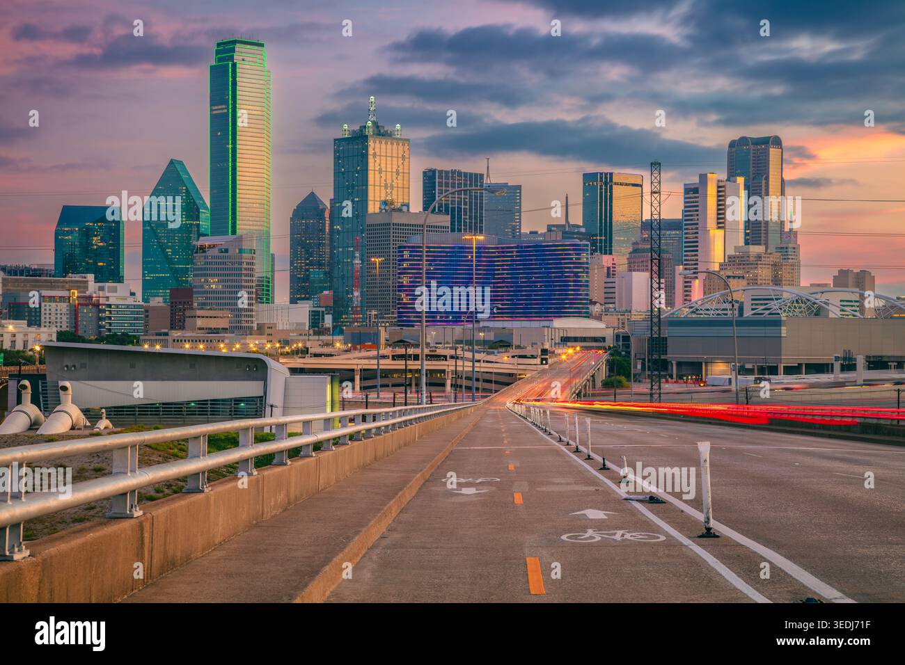 Dallas, Texas, Stati Uniti. Immagine del paesaggio urbano del centro di Dallas, Texas, con superstrada e pista ciclabile che conduce alla città alla splendida alba. Foto Stock
