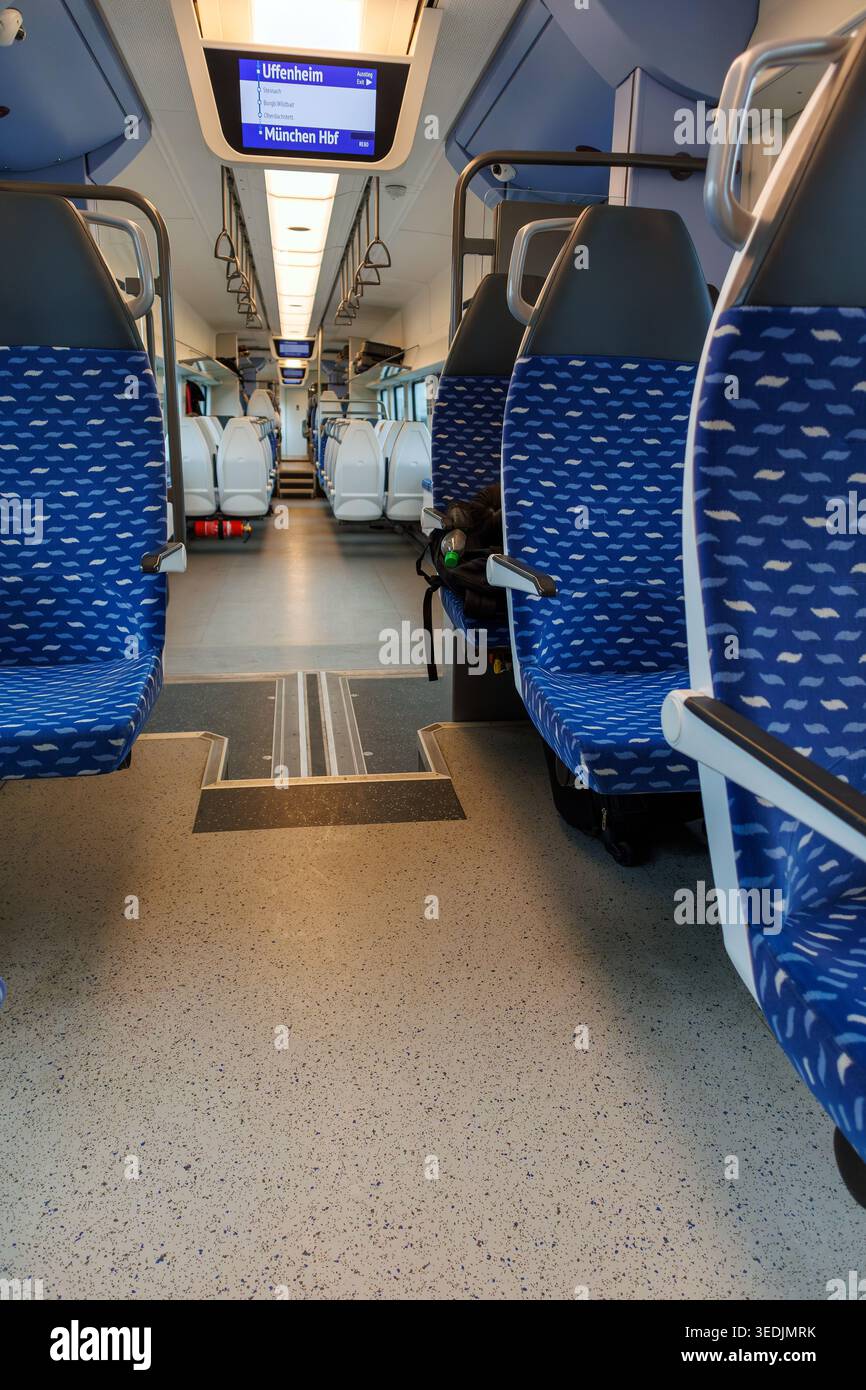 Uffenheim, Germania. 31 marzo 2026. Vista della corsia di un treno regionale della Deutsche Bahn con file di sedili blu vuoti e schermate di visualizzazione in alto. Foto Stock