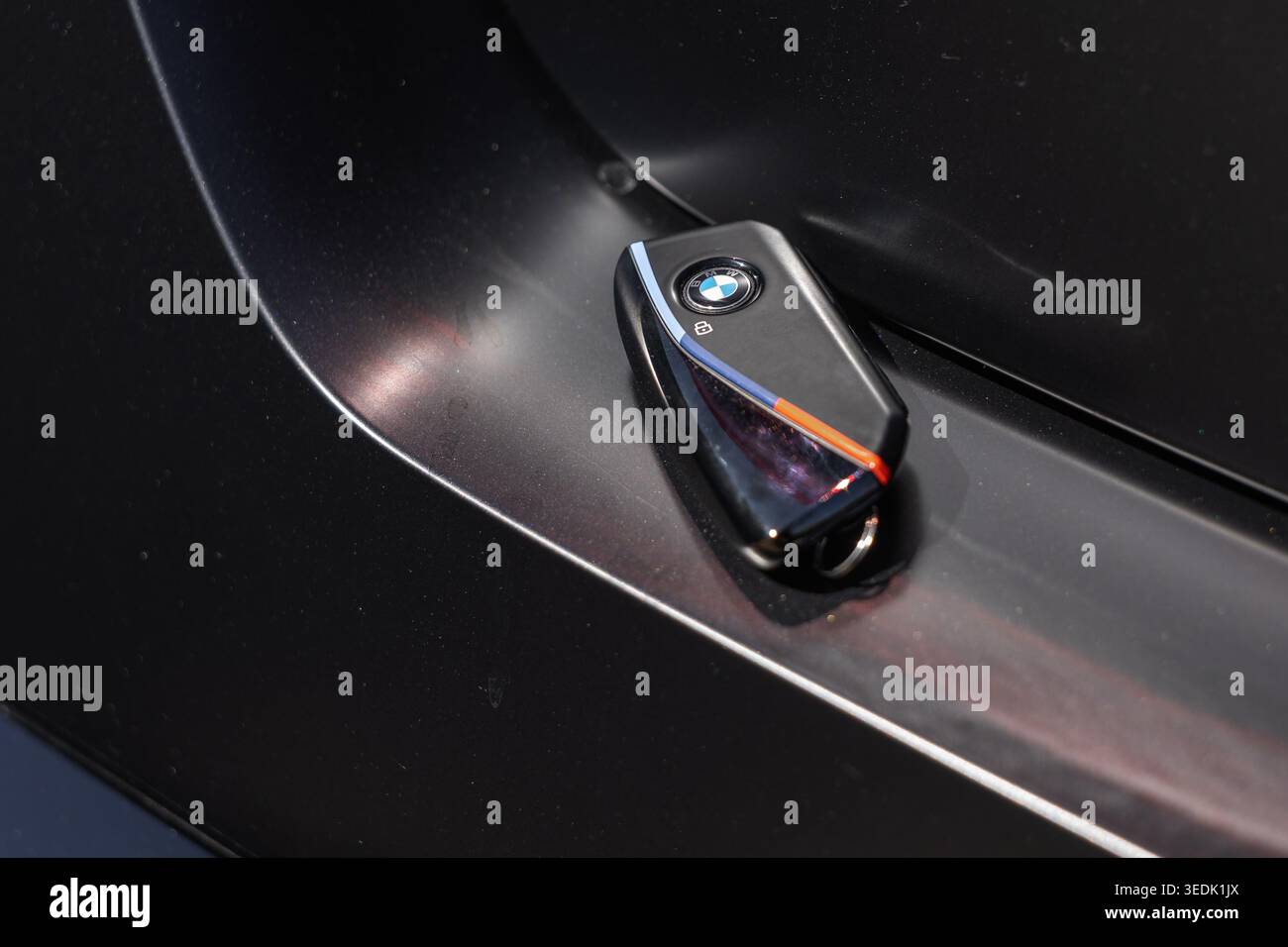 Slovenia, Lubiana - 8 aprile 2026: BMW Key poggia su una maniglia della portiera di lusso in piena luce. Foto Stock