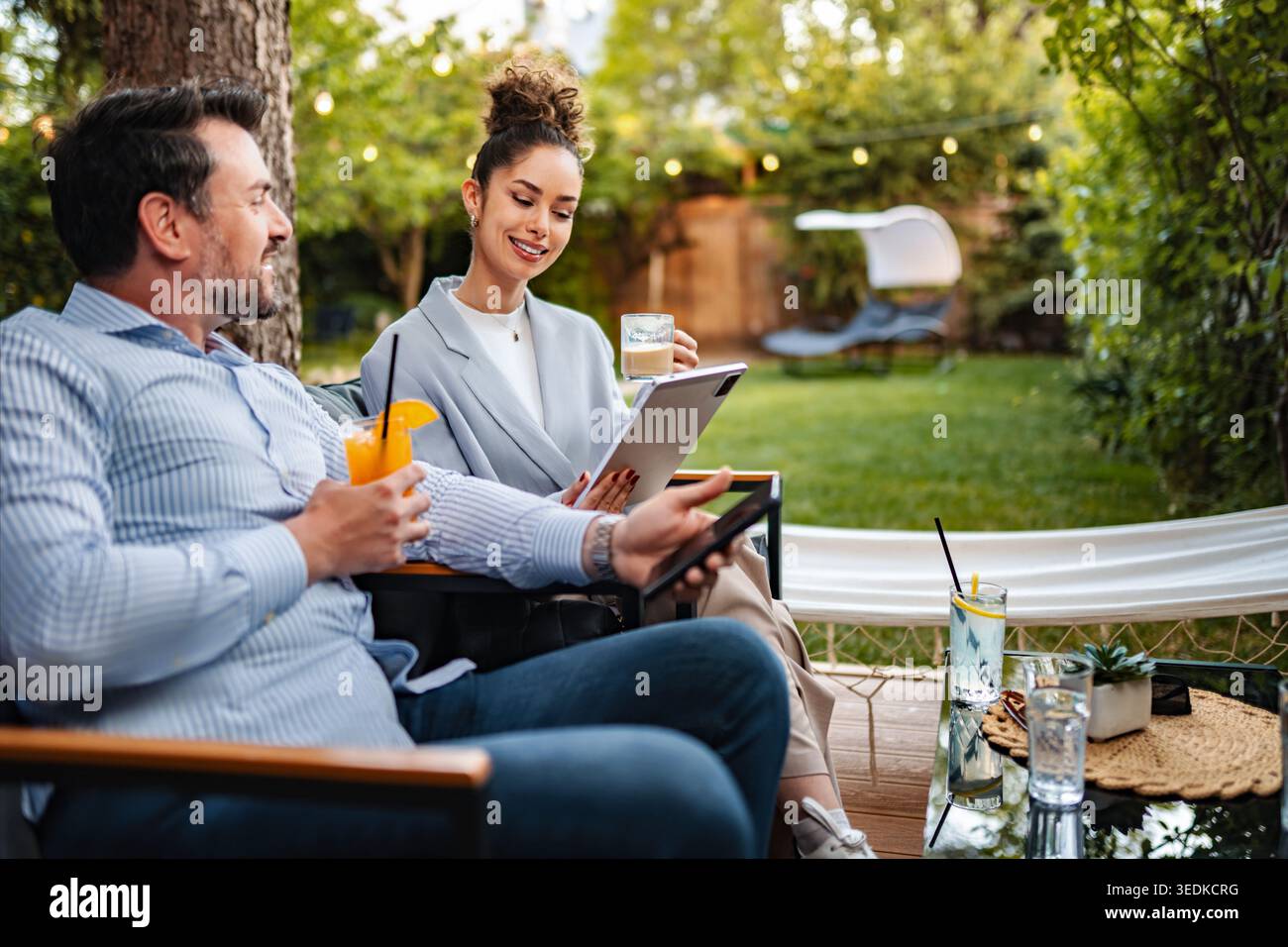 Colleghi che hanno una riunione informale che lavora su un tablet digitale Foto Stock