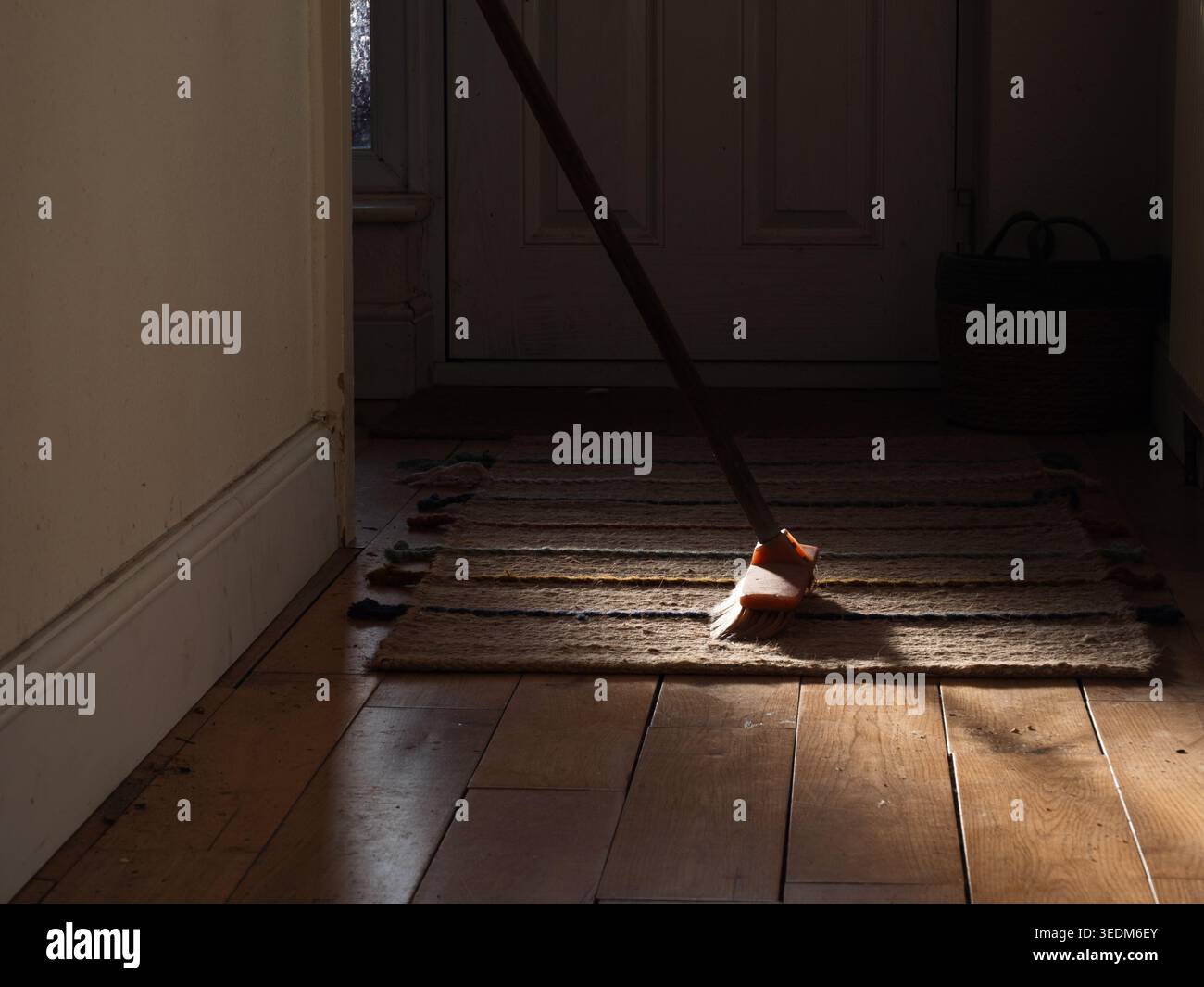 Scopa nel corridoio con pavimento in legno e tappeto Foto Stock
