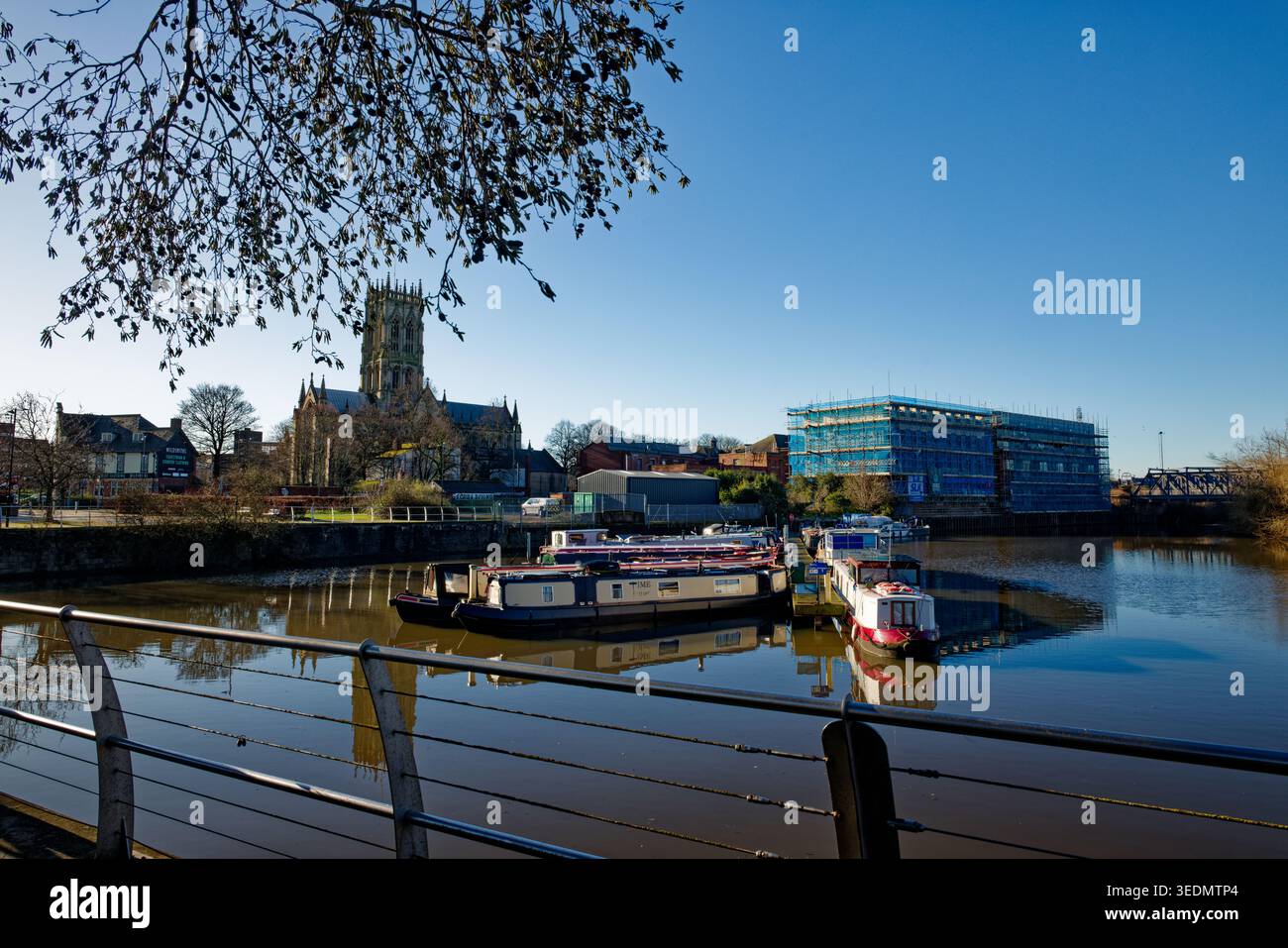 Chiatte ormeggiate su un tratto di urb, un canale con una grande chiesa gotica e un edificio sul litorale in fase di ristrutturazione, Doncaster, South Yorkshire. Foto Stock