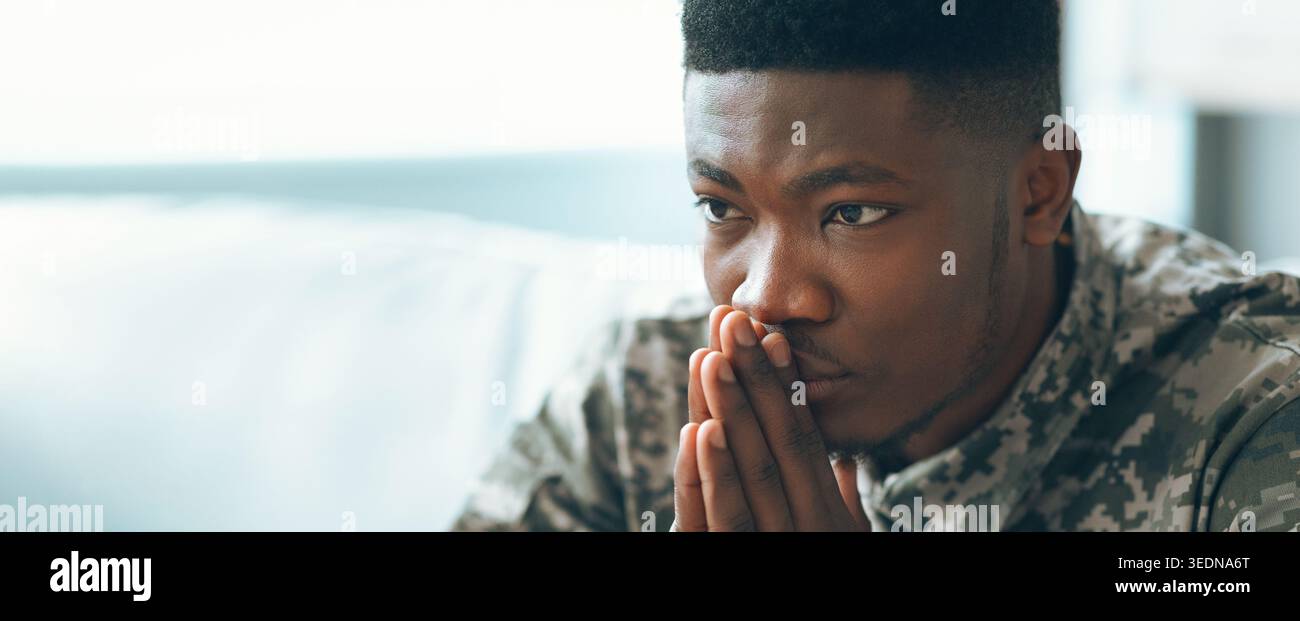 Uomo seduto tranquillamente con le mani legate insieme mentre si è in profondità nel pensiero in una stanza Foto Stock