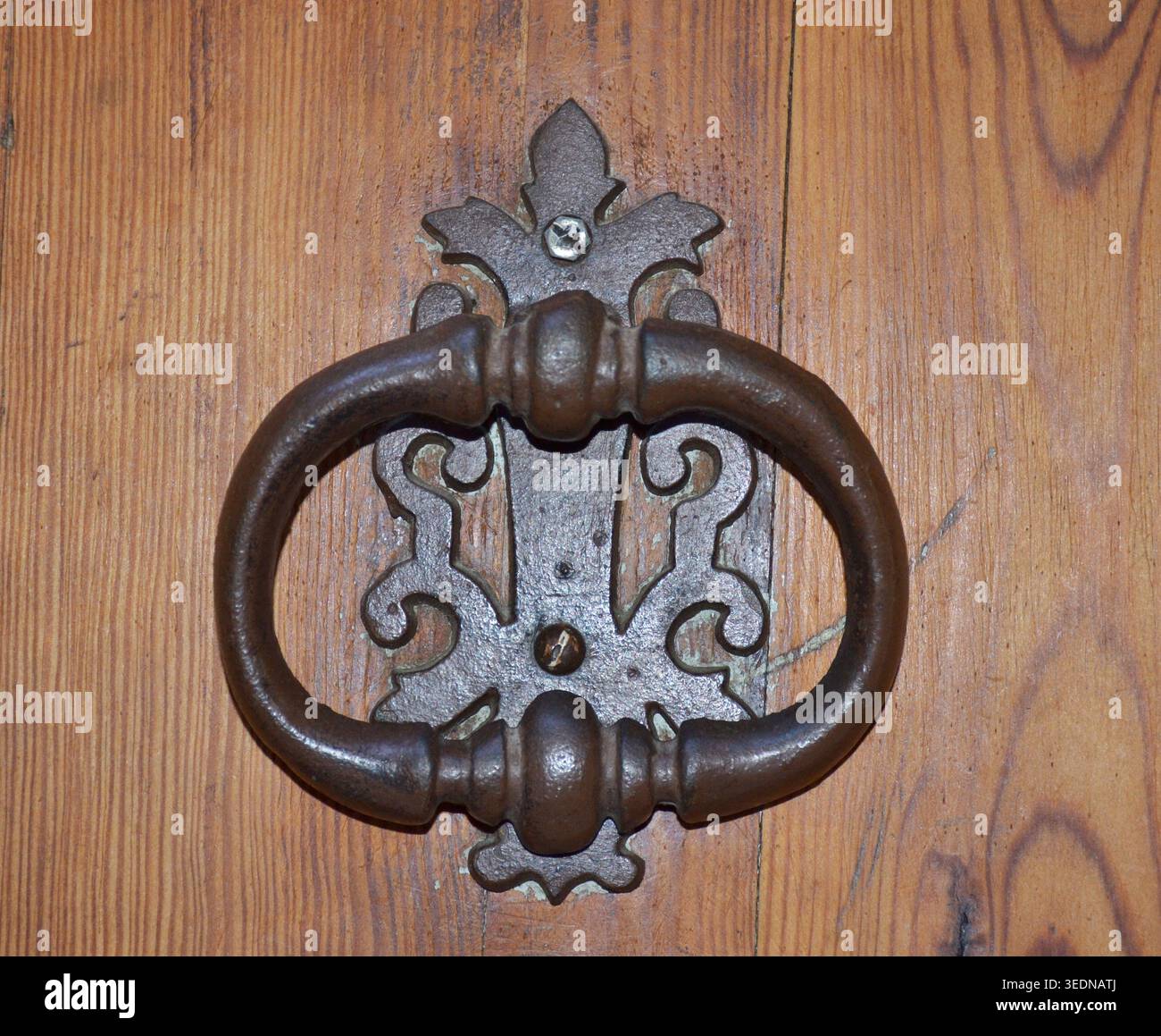 Antica porta di ferro che bussa su una porta di legno rustica Foto Stock