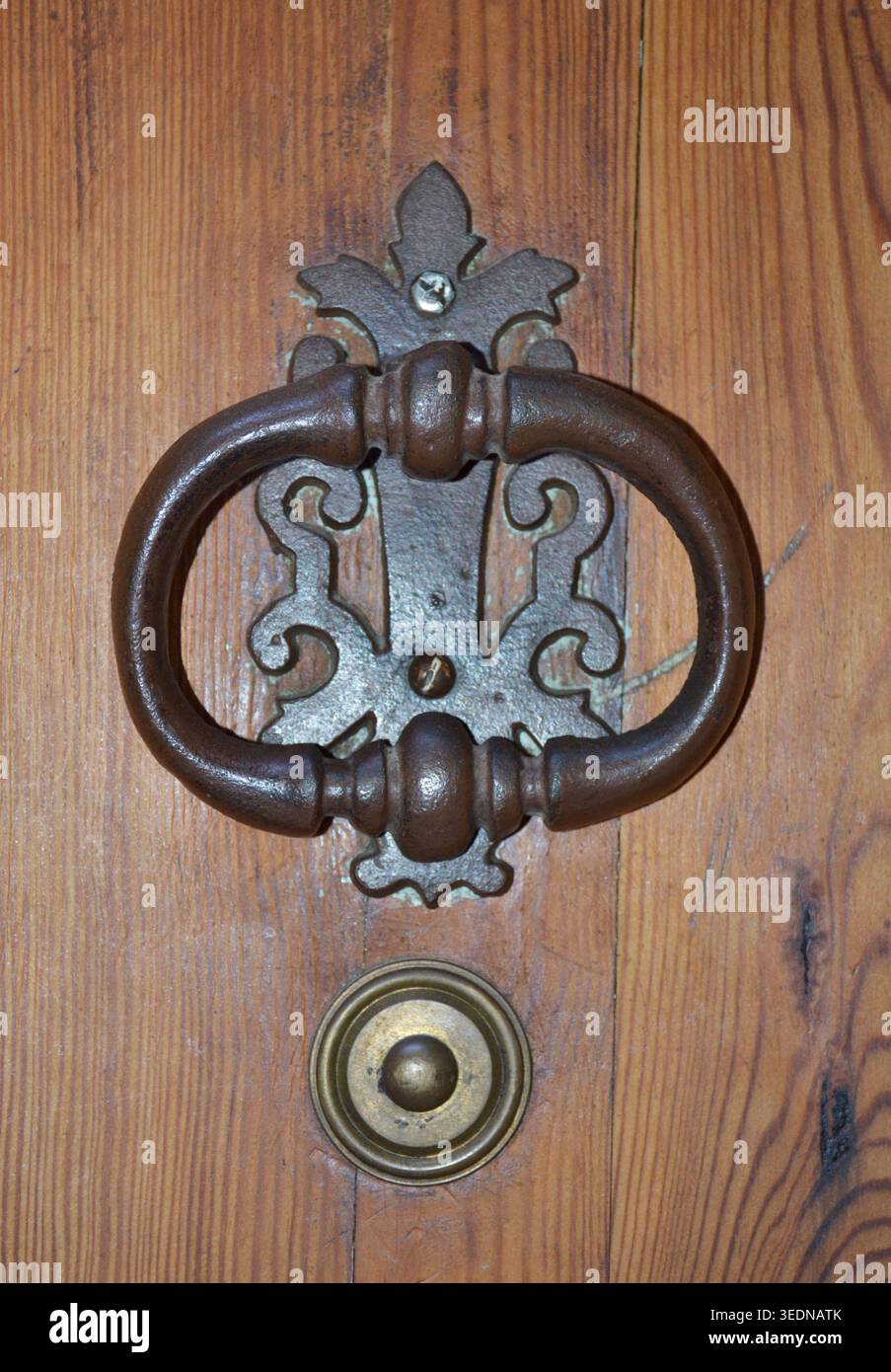 Antica porta di ferro che bussa su una porta di legno rustica Foto Stock