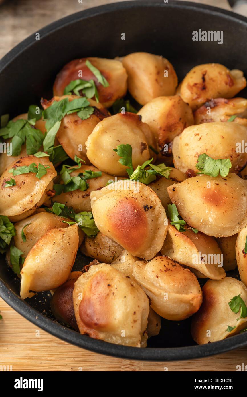 Pelmeni fritti squisiti, ravioli, gnocchi ripieni di carne su una teglia da vicino Foto Stock
