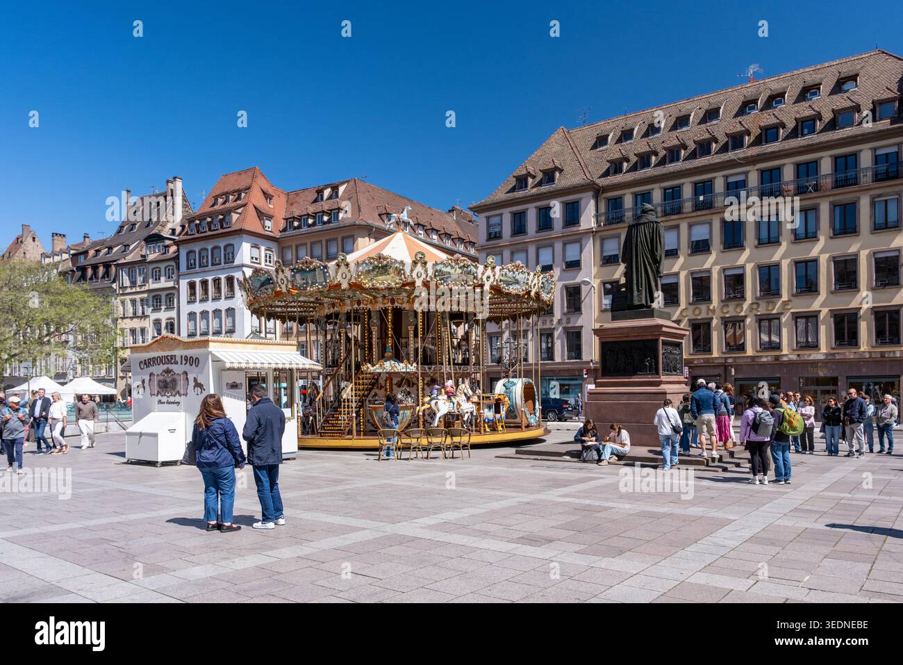 Strasburgo, Francia - 30 aprile 2026: I visitatori si riuniscono intorno a una giostra a Gutenberg Place a Strasburgo. Foto Stock