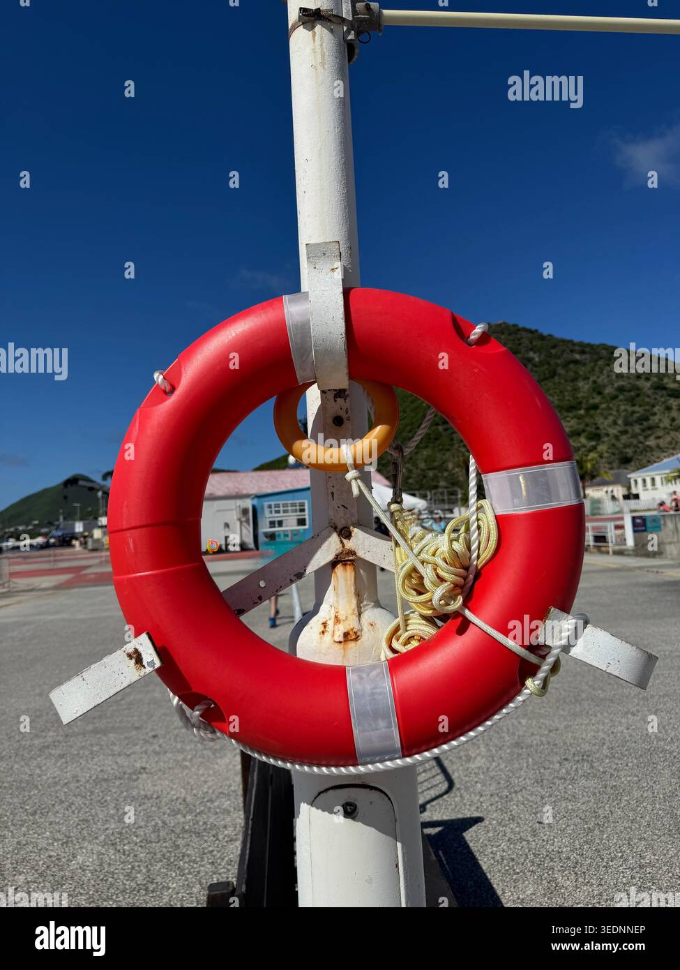 Una visuale stretta e ad alto angolo in basso tra un mega scafo di una nave da crociera attraccata e la parete del molo in cemento. - Immagine stock catturata con smartphone