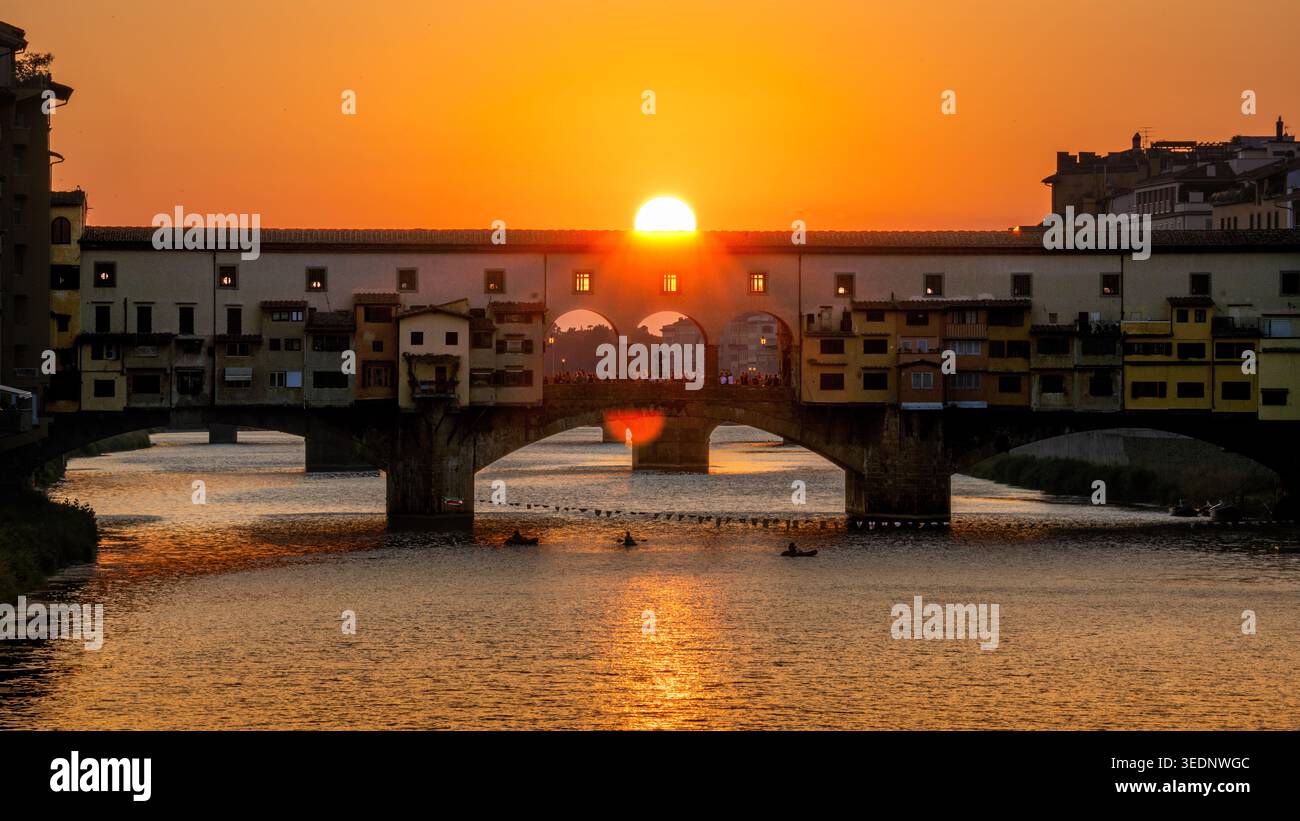 Tramonto dietro l'iconico Ponte Vecchio sul fiume Arno a Firenze, Italia Foto Stock
